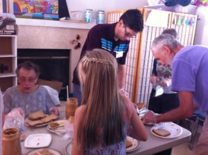 five people making sandwiches